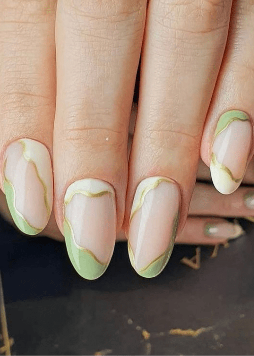 A green, tan, and gold swirly nail design