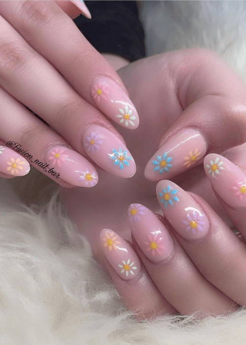 a nail design with little pink, blue, white, and purple flowers