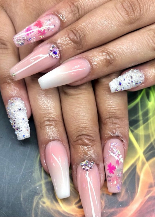 A nail design with pink and white gradient with silver rhinestones