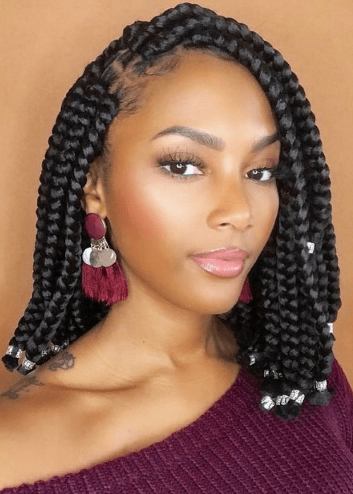 A short braid hairstyle with box braids and silver cuffs