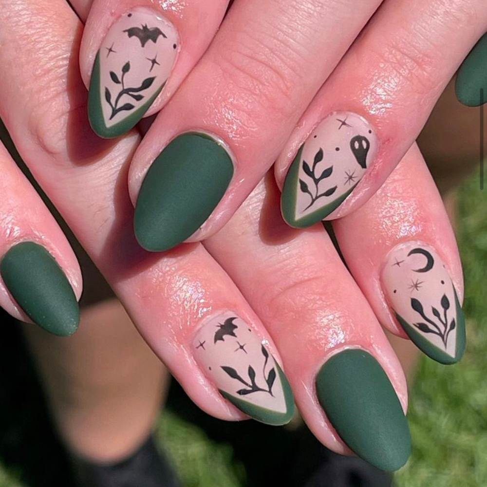 Halloween nail designs: A green nail design with black bats and ghosts