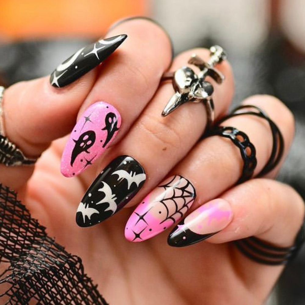 A pink and black halloween nail design with ghosts, bats, and spiderwebs