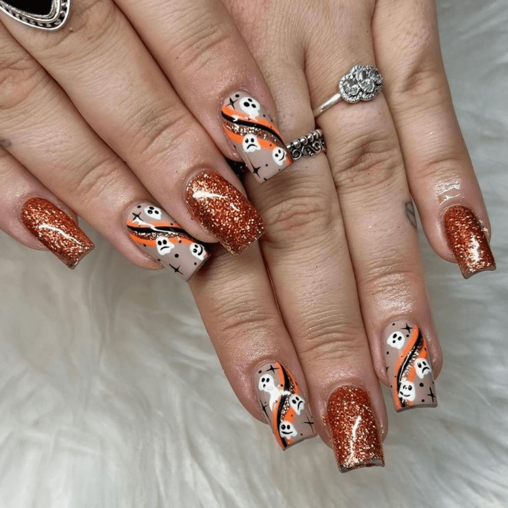 A orange and black ghost nail design with tiny ghosts